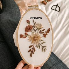 someone is holding up a cross - stitch embroidery