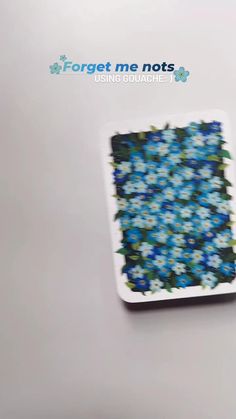 a white plate with blue and green flowers on it, in front of the words forget me nots