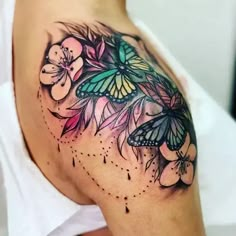 a woman's shoulder with flowers and butterflies on the top of her arm,