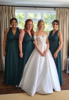 four bridesmaids pose for a photo in front of the window at their wedding