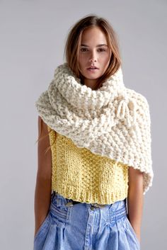 a woman wearing a knitted scarf in yellow and white