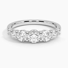 a three stone diamond ring with four stones on the side, set in 18k white gold