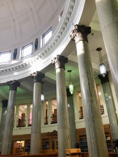 the inside of a library with several columns and lights on each side of the room