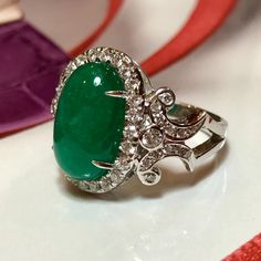 MADE TO ORDER ONLY! 1 week gold crafting period. EXTREMELY VIVID, Certified 7.57 carats, COLOMBIAN Emerald ring. SUGGESTED RETAIL VALUE: $18,000 EMERALD: Weight: 6.63 carats Shape: Oval Cabochon Dimensions: 9.27 x 14.73 x 5.90 mm Color: Green Origin: COLOMBIAN NATURAL EMERALD WITH OIL TREATED ONLY (F3) Gemological certificate provided as shown. TRANSPARENT EXTREMELY CLEAN EXCELLENT COLOR AND CUT! RARE VIVID, COLOMBIAN, BLUISH-GREEN COLOR!! DIAMONDS: 50 round brilliant diamonds weighting a total Luxury Formal Oval Cabochon Emerald Ring, Luxury Diamond Gemstones With Cabochon Cut, Luxury Diamond Cabochon Gemstones, Luxury Oval Cabochon Diamond Gemstones, Exquisite Oval Platinum Gemstones, Luxury Emerald Ring With Oval Cabochon, Luxury Oval Cabochon Emerald Ring, Luxury Emerald Ring With Oval Cabochon And 17 Jewels, Luxury Oval Cabochon Emerald Ring With 17 Jewels