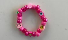 Happy Face emoji bracelet. Stretch elastic. Plastic beads. Lots of smiles. Trendy Smiley Face Stretch Bracelet With Round Beads, Trendy Stretch Bracelet With Smiley Face Round Beads, Playful Stretch Bracelet With Smiley Face For Gift, Playful Smiley Face Stretch Bracelet As Gift, Pink Smiley Face Round Bead Jewelry, Novelty Pink Round Beads Stretch Bracelet, Pink Smiley Face Round Beaded Jewelry, Casual Pink Charm Bracelet With Letter Beads, Playful Pink Beaded Bracelet With Smiley Face