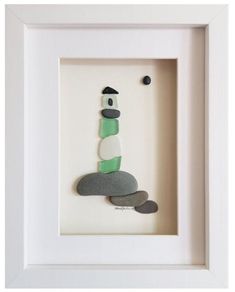 a white frame with a green and black lighthouse in it