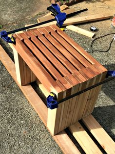 a wooden bench with two skis attached to it's sides and some tools on the ground