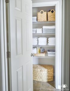 an open closet with baskets and towels on the shelves