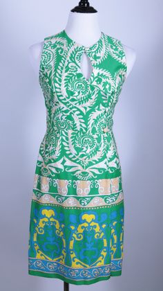 "Put yourself into an island mood the moment you slip this dress on.  The Polynesian Hawaiian Royalty style print lets you be the Monarch of your own personal paradise.   This dress is small with an older size 8 tag, but more of a size 4 in present day measurements.   Button front closure.    32\" bust 27\" waist 34\" Hips 37\" from top of shoulder near neck to bottom hem" Summer Sleeveless Dress With Bold Print, Vintage Sleeveless Beach Sundress, Vintage Sleeveless Sundress For Vacation, Multicolor Sleeveless Hawaiian Dress, Green Batik Print Dress For The Beach, Sleeveless Hawaiian Dress With Tropical Print, Hawaiian Sleeveless Dress With Tropical Print, Sleeveless Green Dress With Vibrant Print, Fitted Green Bohemian Sleeveless Dress