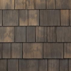 wood shingles on the roof of a house in brown and tan tones, close up