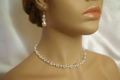 a mannequin head wearing a necklace and earrings