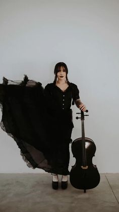 a woman in black dress holding a cello