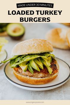 a turkey burger with lettuce and avocado on it