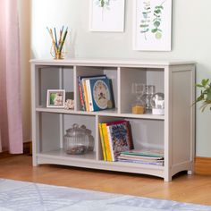 a white book shelf with books and pictures on it