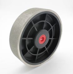 a wheel with red spokes is on a white surface and it appears to be used for grinding concrete