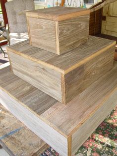 three stacks of wood stacked on top of each other in front of a chair and rug