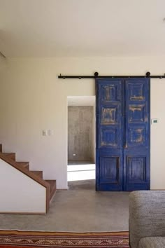 a living room with blue doors and stairs