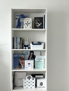 a white book shelf filled with books and magazines