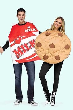 two people dressed in costumes standing next to each other and one holding a giant cookie