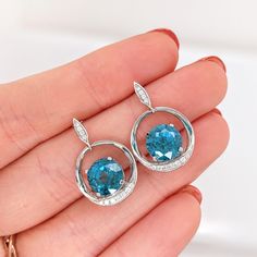 These beautiful drop earrings feature a pair of 10.59 carat weight Blue Zircon gemstones with natural earth mined diamonds set in solid 14K gold. These earrings make a lovely December birthstone gift for your loved ones! These earrings are made with solid 14k Gold and natural earth mined SI / G-H Diamonds. As listed, these earrings are ready to ship. If you're interested in purchasing this setting with a different center stone please message us! Luxury Blue Topaz Drop Earrings, Fine Jewelry Diamond Earrings With Round Stone, Diamond Cut Earrings Fine Jewelry, Elegant Topaz Jewelry With Halo Design, Blue Topaz Earrings With Brilliant Cut As A Gift, Silver Earrings With Brilliant Cut Blue Topaz, Silver Blue Topaz Earrings With Brilliant Cut, Diamond White Gemstone Earrings Fine Jewelry, Diamond White Gemstone Earrings In Fine Jewelry Style