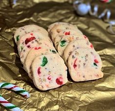 several cookies with candy canes on top of foil next to peppermint sticks