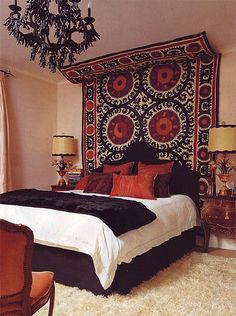 a large bed sitting in a bedroom under a chandelier