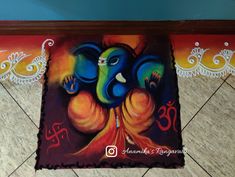 an elephant painting on the floor in front of a wall with decorative designs and colors