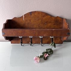 an old wooden coat rack with hooks and flowers