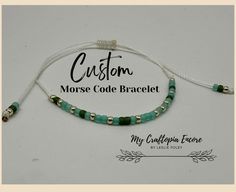 a bracelet with green beads and gold accents on white string that says custom morse code bracelet