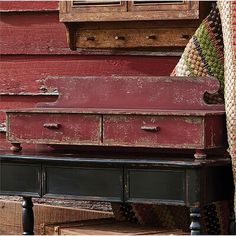 an old trunk sitting on top of a wooden table next to a red barn door