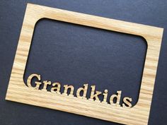 the word grandkids is cut out of wood and placed on a black surface