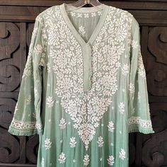 This Ombre Green Lucknowi Chikankari Muslin Kaj Patti Frill Kurti is a staple for any wardrobe. Crafted from Muslin Silk, this piece offers a stylish, elegant look with a frill design detail on the neck and sleeves. A-Line Muslin silk Length 45" inches Long sleeves 18" inches V neck Chikankari embroidery Hand embroidered Dry Clean Fit: True to sizeInside Margin: NoTouch and Feel: Soft and ComfortableDispatched in 1-3 business days Disclaimer: Since the product is hand embroidered, Motifs may var Lehenga Green, Lucknowi Kurta, Chikankari Lehenga, Patiala Salwar Suits, Ombre Green, Chikankari Embroidery, Trendy Outfits Indian, Bridal Dupatta, Lucknowi Chikankari