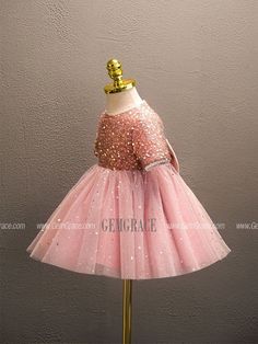 a pink dress with gold sequins on the top and bottom, sitting on a mannequin