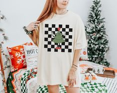 Checker Christmas Tree t-shirt.  These tees are Comfort Colors and are made to last using premium ringspun cotton, this creates an vintage-soft shirt. The soft-washed, garment-dyed fabric brings extra coziness to your wardrobe while the relaxed fit makes it an excellent daily choice. ✦ 100% Ringspun Cotton ✦ Relaxed fit ✦ Medium fabric ✦ Sewn-in twill label ✦ Eco-friendly, Ethically Made & Sweatshop Free ✦ Printed to order with non-toxic ink ✦ Durable and Long-lasting ✦ Shirts are pre-shrunk but may shrink slightly after washing ✦ Made to order: *Please allow 2-5 business days to print before being shipped* Sizing Recommendation: ✦ See size guide in images above ✦ This is a unisex t-shirt. Order your usual size for a relaxed fit, size down by one if you prefer a more fitted look, or size u Christmas Graphic Tee Shirt In Cotton, Christmas Cotton Graphic Tee Shirt, Tailgate Clothes, Funny Sports Shirts, Cherry Shirt, Retro Christmas Shirt, Color Checker, Xmas Tees, The Only Exception