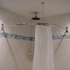 the shower curtain is open in this bathroom with white tile walls and floor tiles on the wall