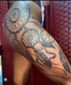 a woman's leg with tattoos on it and an image of a dream catcher