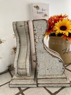 a vase filled with flowers next to a wooden letter