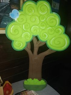 a green plastic tree sitting on top of a table