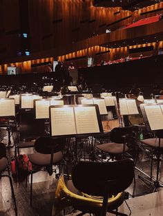 an empty concert hall with lots of chairs and sheet music on the tables in front of them