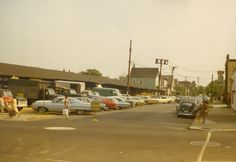 an old photo of cars parked on the street