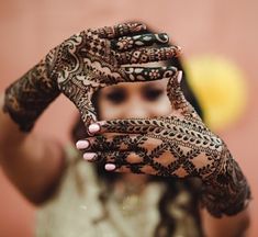 a woman holding up her hands with henna on it