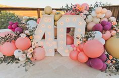 the letters are decorated with balloons and flowers