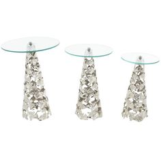 three glass and metal tables with flowers on each table top, one in the shape of a cone