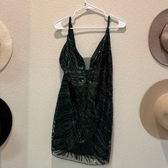 hats are hanging on the wall next to a dress and hat rack with an open - back top