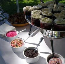 cupcakes, muffins and sprinkles are on the table