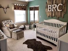 a baby's room is decorated in brown and green tones with deer heads on the wall