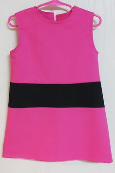 a pink and black dress hanging on a wall