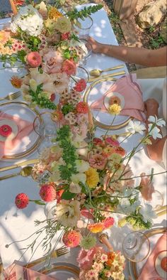 the table is set with pink and white flowers