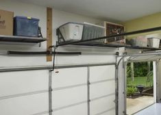 an overhead garage door is open to show the inside and outside spaces that are being used for storage