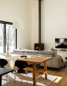 a living room filled with furniture and a fire place next to a large glass window